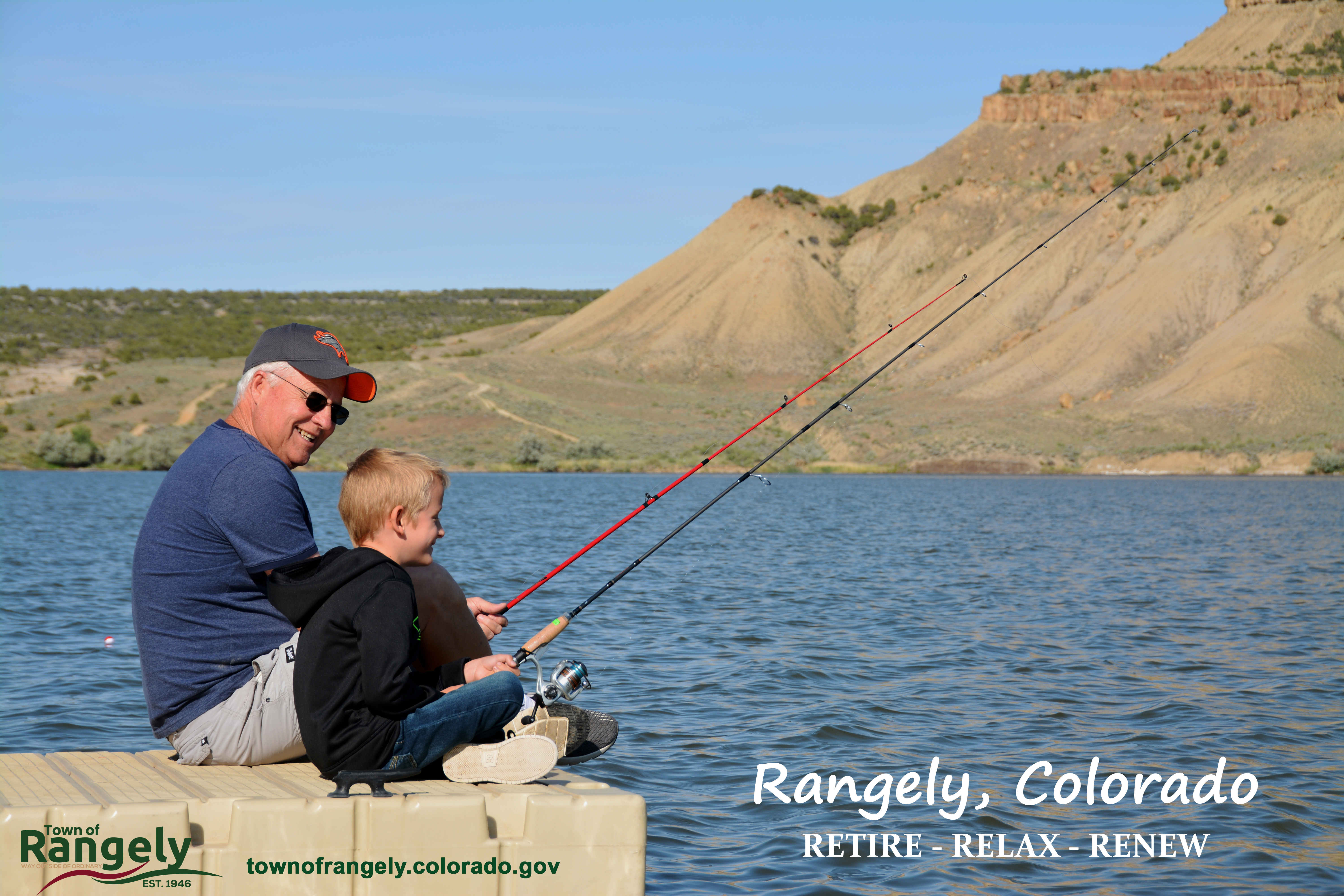 Grandpa and Grandson fishing off at deck at Kenney Reservoir during the summer